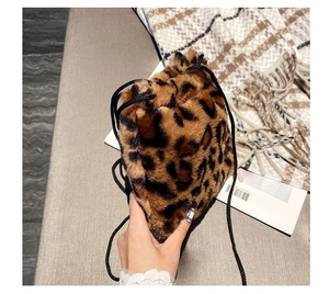 Close-up of leopard print faux fur bucket bag with a black drawstring closure