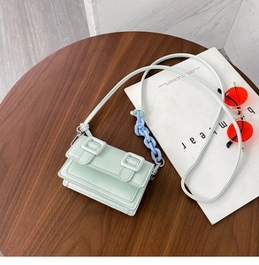 Detail of light green PU leather mini crossbody bag with blue chain link and flip cover