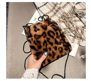 Detailed view of plush leopard print faux fur bucket bag with black drawstring closure