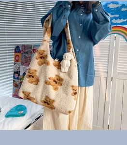 Dettaglio della borsa tote in pile beige con motivo a orsetto e ciondolo di peluche