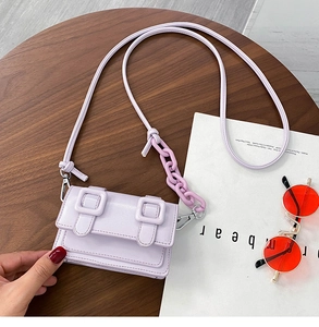 Detail of lavender mini crossbody bag with decorative plastic chain and double buckle straps
