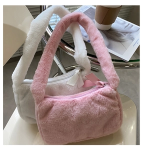 Detail of plush faux fur shoulder bag with soft texture and chic ribbon zipper puller
