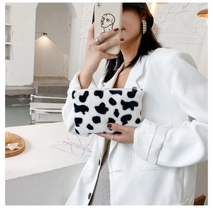 Détail du petit porte-monnaie en peluche à motif vache avec une fermeture éclair en métal