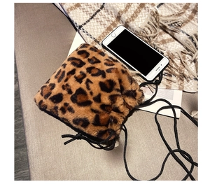 Detail of leopard print faux fur bucket bag with drawstring closure and phone comparison