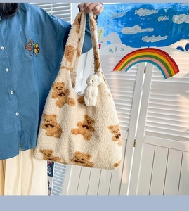 Dettaglio della borsa tote beige pelosa che mostra texture morbida e stampe di orsi
