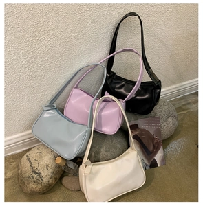 Close-up of minimalist faux leather shoulder bags in blue, purple, black and white colors