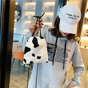 Faux fur drawstring bucket bag with black and white cow print for autumn winter