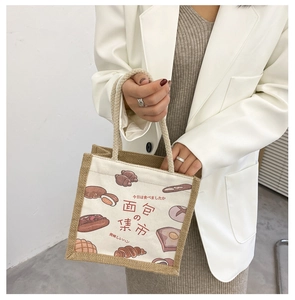 Detail of canvas tote bag with hand-drawn bread illustrations and textured burlap edges