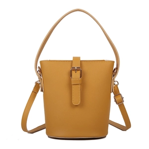 Minimalist bright yellow bucket bag in faux leather with adjustable strap and top handle