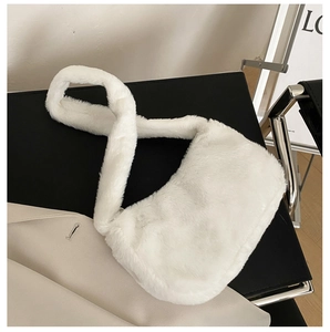 Close-up of fluffy white faux fur underarm bag with a thick plush handle and soft texture