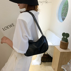 Minimalist black leather half-moon hobo bag styled as a trendy shoulder bag for women