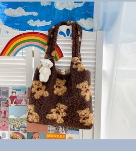 Dettaglio di una borsa tote marrone con orsetto e ciondolo in peluche in stile autunnale