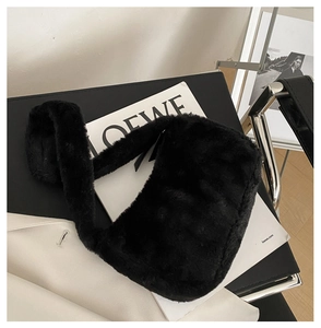 Close-up of black plush faux fur shoulder bag texture with wide furry handle detail