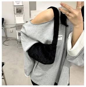 Detail of black faux fur hobo bag showing soft texture and half-moon shoulder design