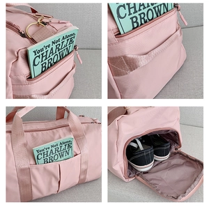 Vue détaillée du sac de voyage rose montrant poches latérales, anneaux et compartiment à chaussures