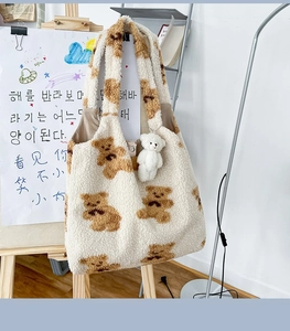 Dettaglio della borsa tote in peluche beige con motivi a orsetto e chiusura magnetica