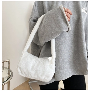 Close-up of white faux fur shoulder bag texture with soft plush finish and zipper detail