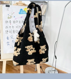 Dettaglio della borsa tote in peluche nera con stampe di orsetti e ciondolo orsetto