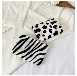 Vue détaillée des porte-monnaie en peluche motifs vache et zèbre avec fermeture éclair