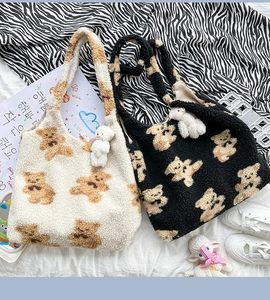 Dettaglio delle borse tote in pile con motivi di orsi e ciondoli a forma di peluche