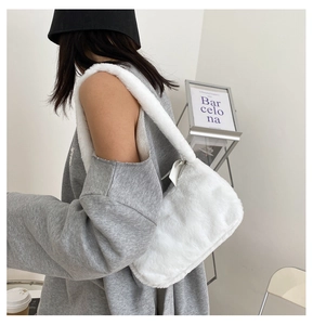 Close-up showing a model wearing a fluffy white plush baguette shoulder bag for winter