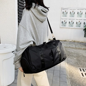 Sac de voyage noir grande capacité avec séparation sec-humide dans un décor moderne