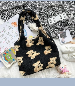 Dettaglio borsa tote in pile nero con stampa di orsetti e ciondolo di peluche