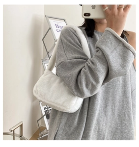 Detailed close-up of a white faux fur shoulder bag with soft plush texture and matching strap