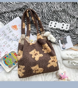 Dettaglio della borsa tote in morbido peluche marrone con motivi di orsi e ciondolo a pecora