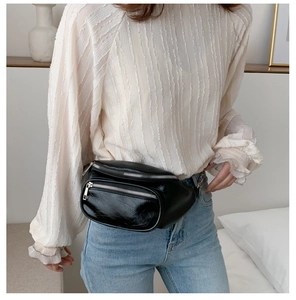 Détail d'un sac banane plissé noir avec zips argentés porté à la taille par un mannequin