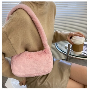 Detail of pink faux fur shoulder bag with satin bow zipper and fuzzy handle on model