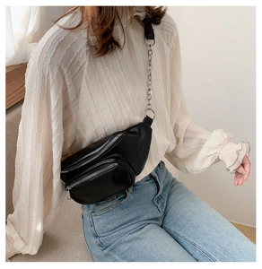 Détail du sac de poitrine en similicuir noir avec triple fermeture éclair et chaîne