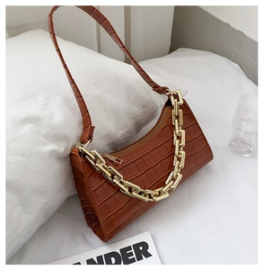 Detail of brown croc-effect hobo bag with a decorative chunky gold square chain strap