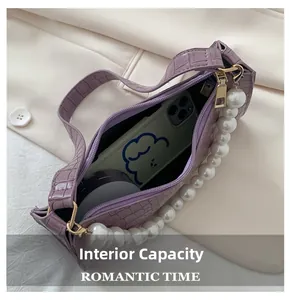 Detail view showing internal capacity of the lavender crocodile pattern shoulder bag
