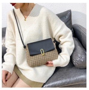 Close-up of stylish houndstooth crossbody bag with elegant gold U-shaped metal clasp