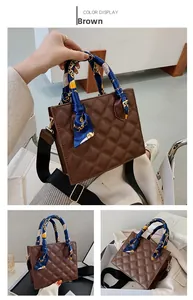 Detail view of brown quilted handbag with silk scarf handle and wide textile strap