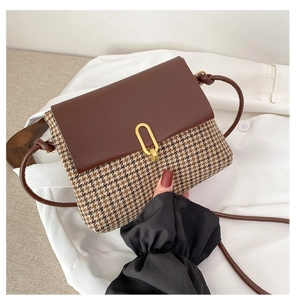 Detail of tweed crossbody bag with houndstooth pattern and golden U-shaped lock
