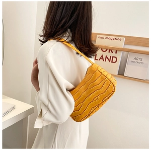 Detailed view of a bright yellow crocodile pattern faux leather baguette shoulder bag