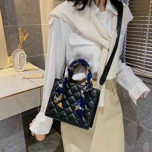 Classic black quilted square handbag with silk scarf detail and wide woven strap