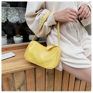 Close-up of vibrant yellow PU leather baguette bag with a sleek matching zipper puller