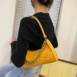 Fashionable orange crocodile pattern underarm bag with gold chain strap on model