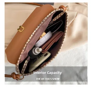 Macro shot of brown houndstooth crossbody bag interior showing phone and makeup storage