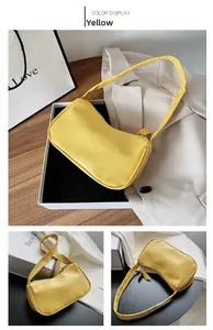 Detail view of a yellow faux leather baguette bag with minimalist zipper and slim strap