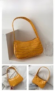 Detailed macro view of yellow crocodile pattern faux leather on this stylish baguette bag