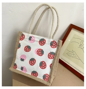 Close-up van canvas draagtas met aardbeienprint en handvatten van henneptouw