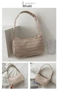 Detailed views of the khaki baguette bag showing embossed crocodile texture and metal zipper
