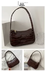 Detailed view of a dark brown baguette bag with glossy crocodile embossed texture