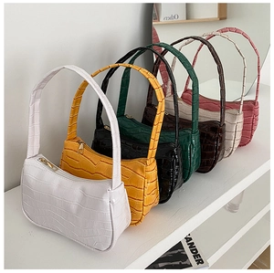 Detailed view of striped baguette shoulder bags in multiple colors with crocodile texture