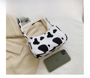 Detail view of cow print tote bag made of high-quality fabric on a soft beige background