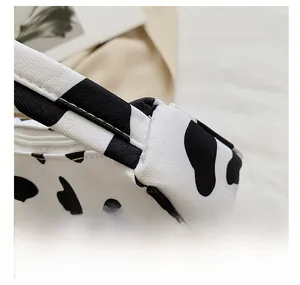 Detail showing reinforced stitching on the shoulder strap of the cow print tote bag